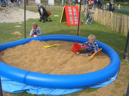 Kinderen vermaken zich in een graanbak! Weer eens iets anders dan een zandbak en ballenbak!